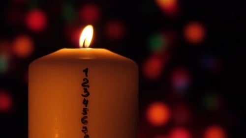 Candle Burning with Flickering Flame at Night