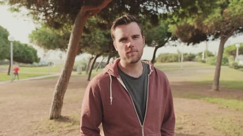 Young man looking at the camera while standing in the park