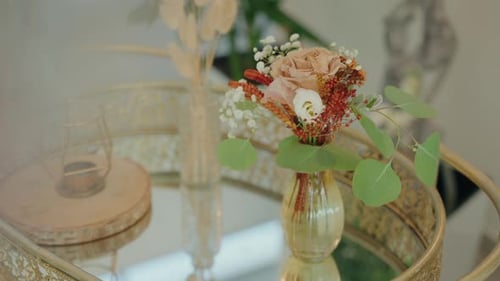 delicate wedding floral arrangement in gold vase on mirrored tray