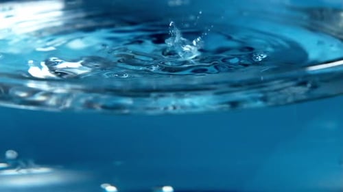 Water Drops Creating Ripples on Blue Background