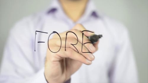 Adult Writing FOREX on Clear Surface