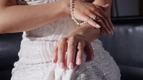 Woman in Gown Adorns Herself with Classic Jewelry