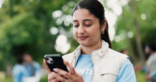 Laughing, phone and volunteer woman in park for charity, community outreach or donation update