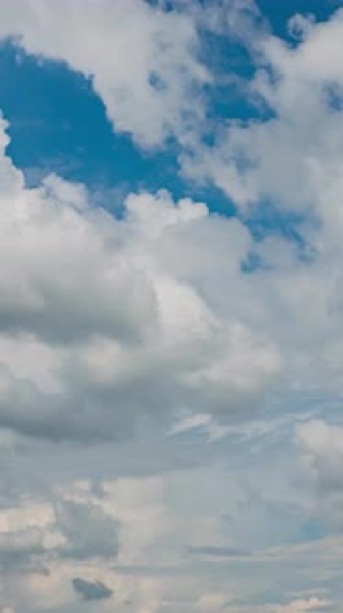 Wunderschöner Sommertagshimmel mit flauschigen weißen Wolken im Zeitraffer in hellblauer Atmosphäre.
