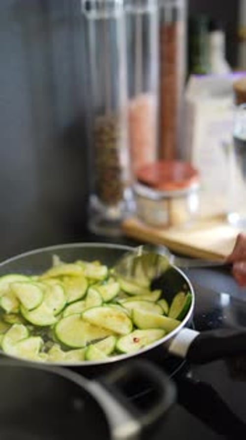 Zucchini Slices Cooking in a Pan on Stove