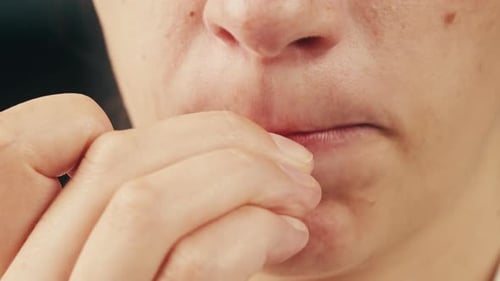 Une femme se ronge les ongles, tics nerveux, troubles obsessionnels compulsifs, patiente d'une clinique psychiatrique