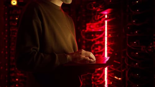Close up of a man trying to fix an error on a computer in a server room