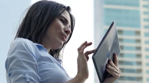 Young businesswoman browsing online with tablet on city terrace