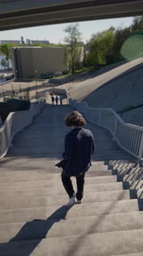 Person Walking Down Concrete Steps in Urban Setting