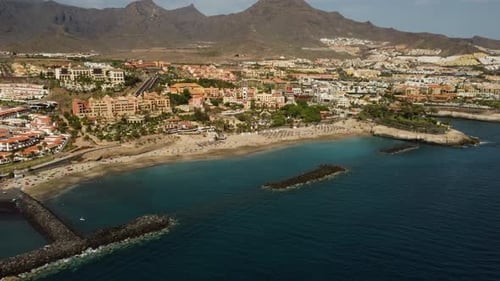 Amazing Drone Shot of Seashore Seaside Of City With Buildings With Mountains In The Background Blue