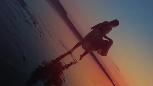Mädchen geht abends am Ufer des Strandes spazieren