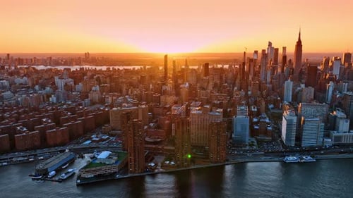 Flight over the East River at sunset time. Revealing view on splendid New York