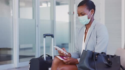 Mature Black Businesswoman Using Mobile Phone at the Airport in the Waiting