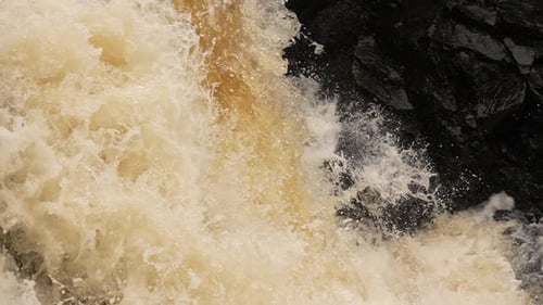 Slow motion water cascading down a waterfall in a violent force of nature.