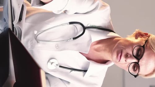 Medical Professional Reads X-Ray and Medical Book