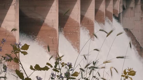 Water flowing through the floodgate of a dam producing sustainable renewable energy. Electrical powe