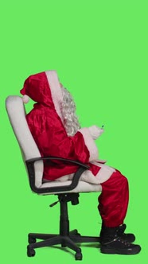 Vertical Video Profile of Thoughtful Santa in Red Suit on Chair