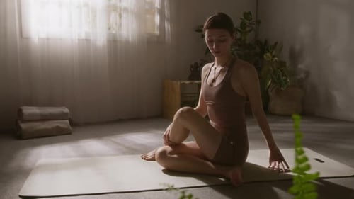 Woman on Yoga Mat Practicing Spinal Twist