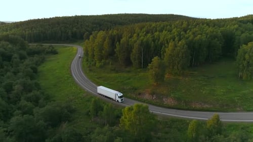 Top View of Beautiful Highway with Truck in Wooded Area Scene Trucker on White Truck is Driving