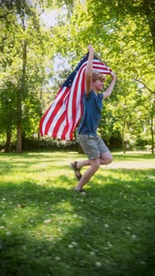 Boy Runs With USA Flag in the Park