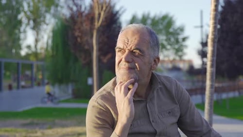 Elderly Man Contemplating Life in the City Park