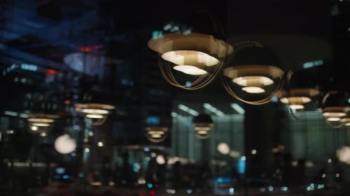 Blurred Interior of the Restaurant with Bright Lighting and People Partying Reflecting in the Window