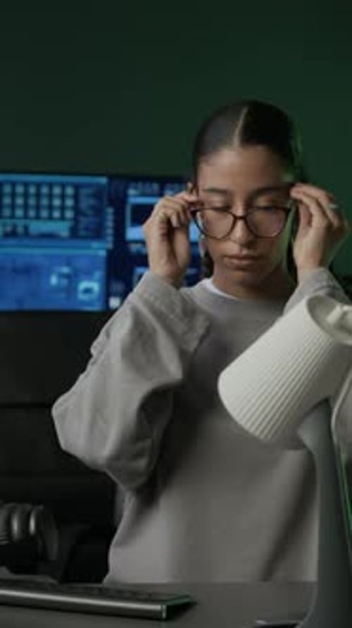 Vertical of Young Female Programmer Getting Ready to Work in Office at Night