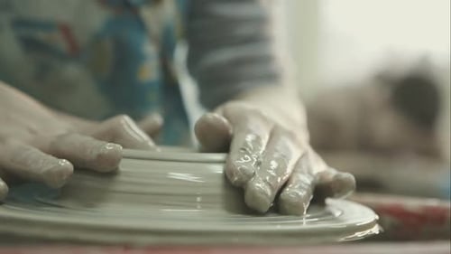 Mains de femme fabriquant un bol en céramique sur la roue du potier