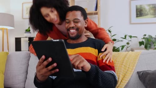 Happy Couple Using Tablet at Home on Sofa