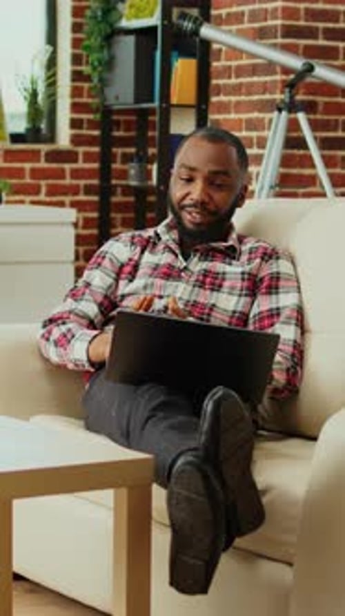 Man Relaxing at Home on Laptop Video Call
