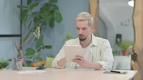 Young Adult Communicating on Tablet Appears Upset
