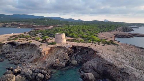 mediterranean coastal sunset ancient historic tower. Wonderful aerial top view flight descending dro