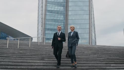 Mature Business Partners Walking Downstairs in City Center