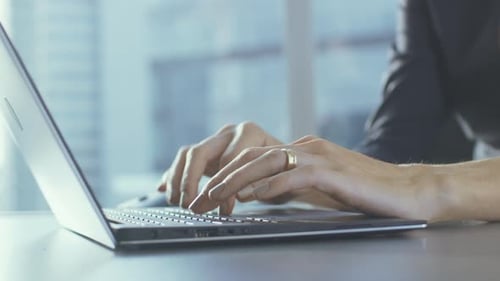 Close-up of the Businesswoman's Hands Typing on a Laptop in Her Office.