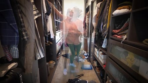 A woman is spring cleaning in a spacious luxury walk in wardrobe. Timelapse.