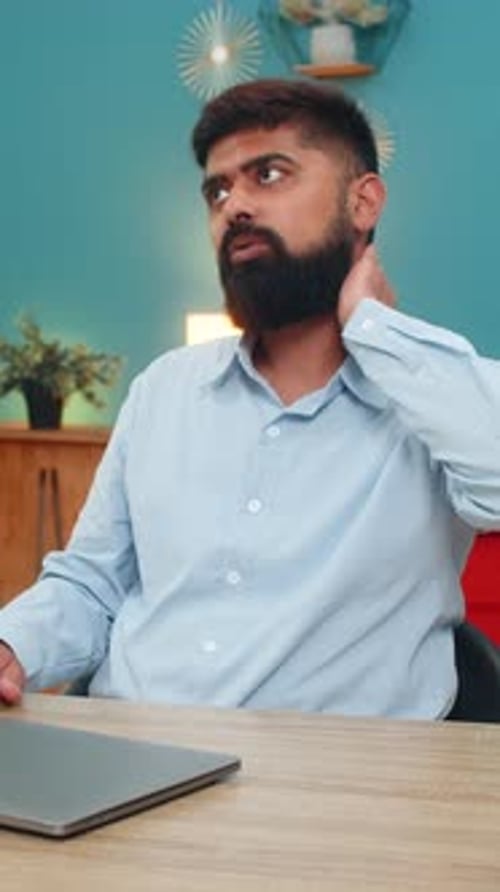 Man Massages Neck After Using Laptop