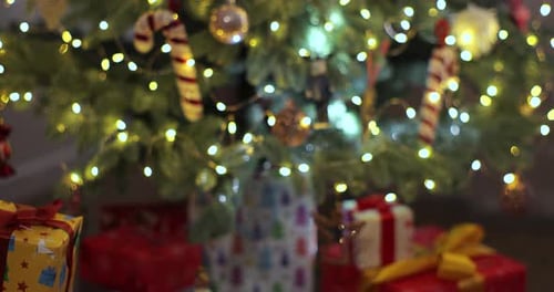 Gift Exchange Beneath Christmas Tree with Warm Lights