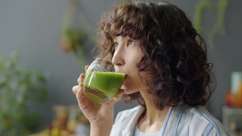 Portrait of Young Woman Drinking Green Smoothie