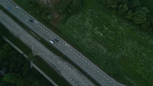 Luftaufnahmen einer Autobahn in Bewegung, umgeben von üppigem Grün, zeigen fahrende Fahrzeuge in Echtzeit
