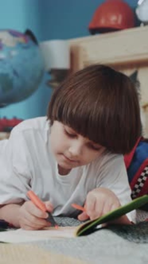 Young Boy Creating Art with Focused Expression Child Engaged in Coloring Using Vibrant Marker and