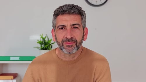 Mature Businessman Smiling at Camera Sitting at Office Workplace