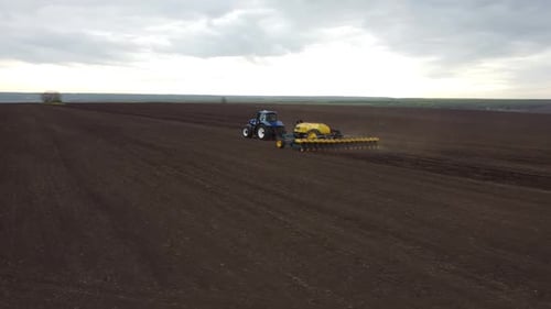 Blue tractor OA working on the field in Ukraine