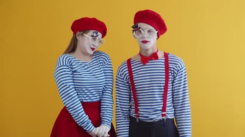 Paar Kaukasier in weißem Make-up auf gelbem Hintergrund