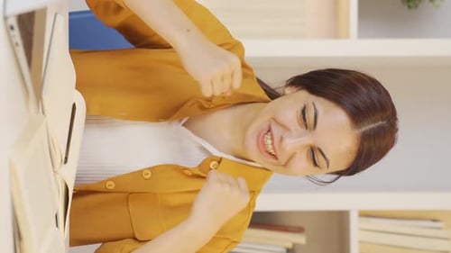 Woman Smiling While Writing in Book at Desk