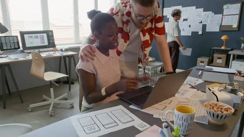 Black Female UX Designer Using Laptop while Creating Mobile App at Office