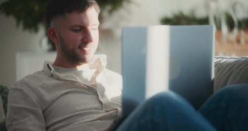 Young Man Relaxing at Home with Laptop