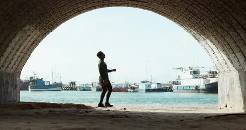 Running, fitness and man rest in tunnel by sea for marathon training, exercise and cardio workout