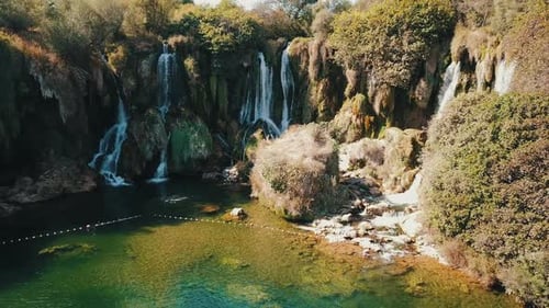 aerial shot of drone flying above beautiful tropical waterfall