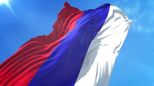 Waving Flag with Red, Blue, and White Stripes Against Blue Sky