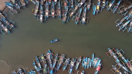 Aerial view of fishing boats lining the Cokel River in Pacitan, Indonesia.